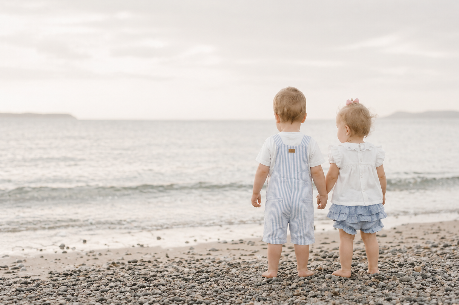 Two children holding hands on a beach