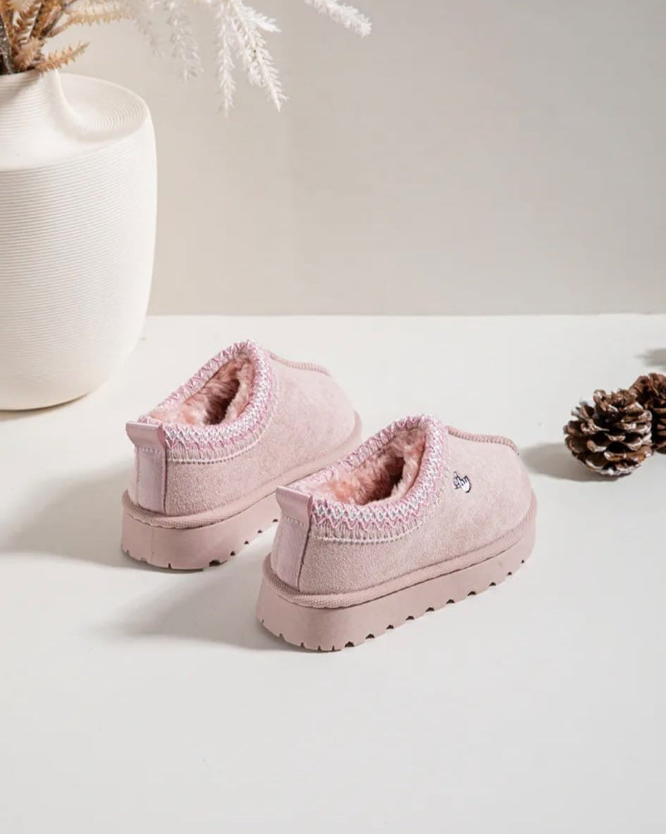 Pair of pink children's boots on a white surface with decorative elements.