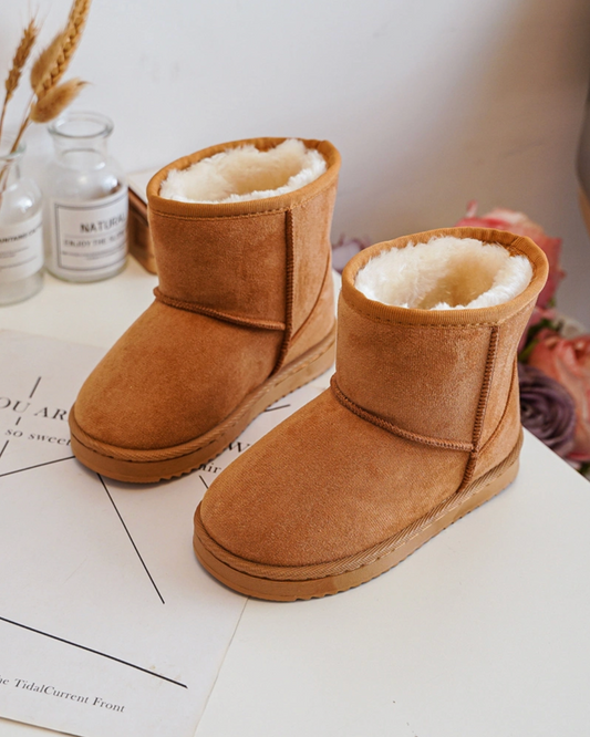 Pair of brown UGG boots on a white surface with a blurred background