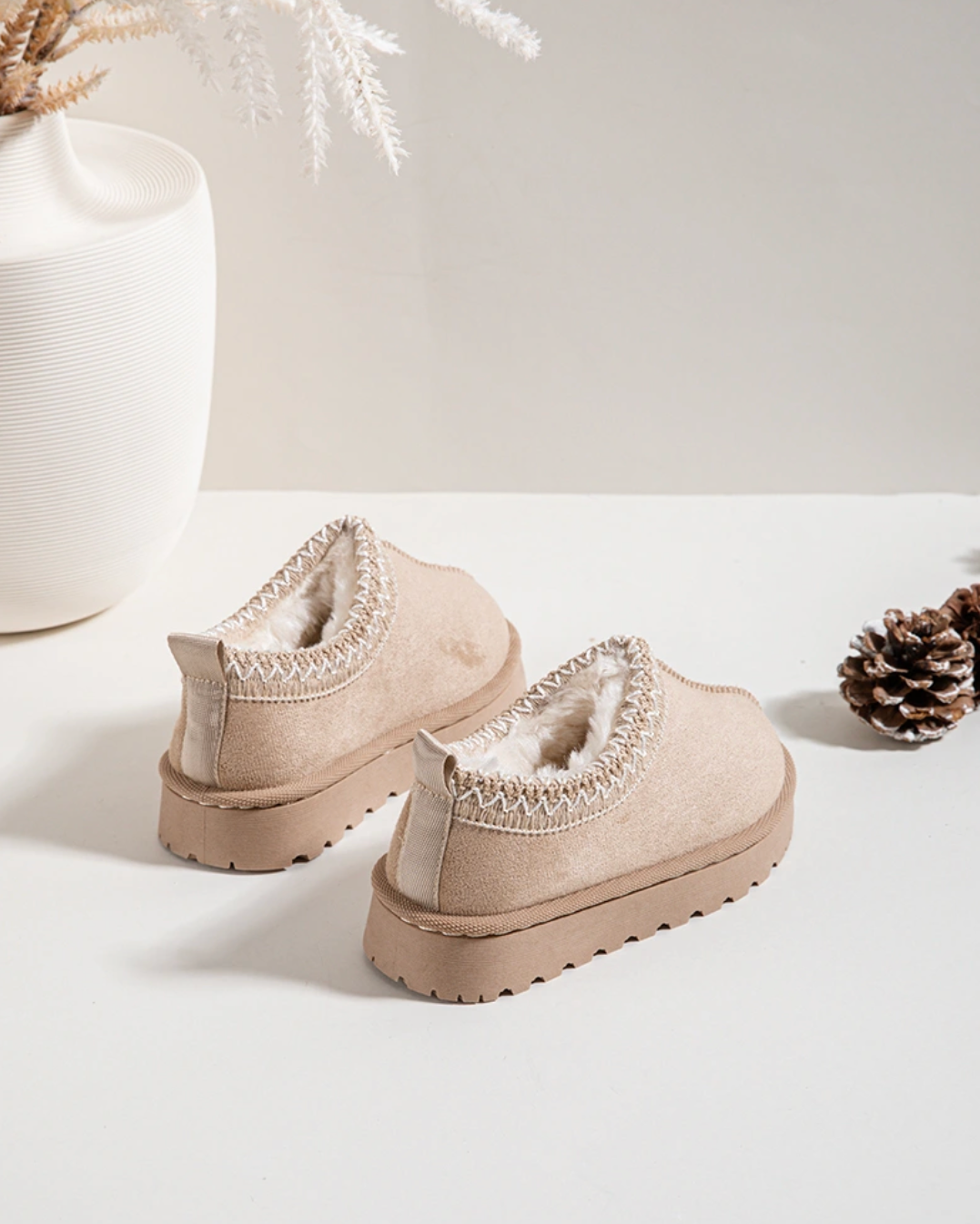 Pair of beige platform shoes with decorative elements on a light background, displayed on a smartphone screen.